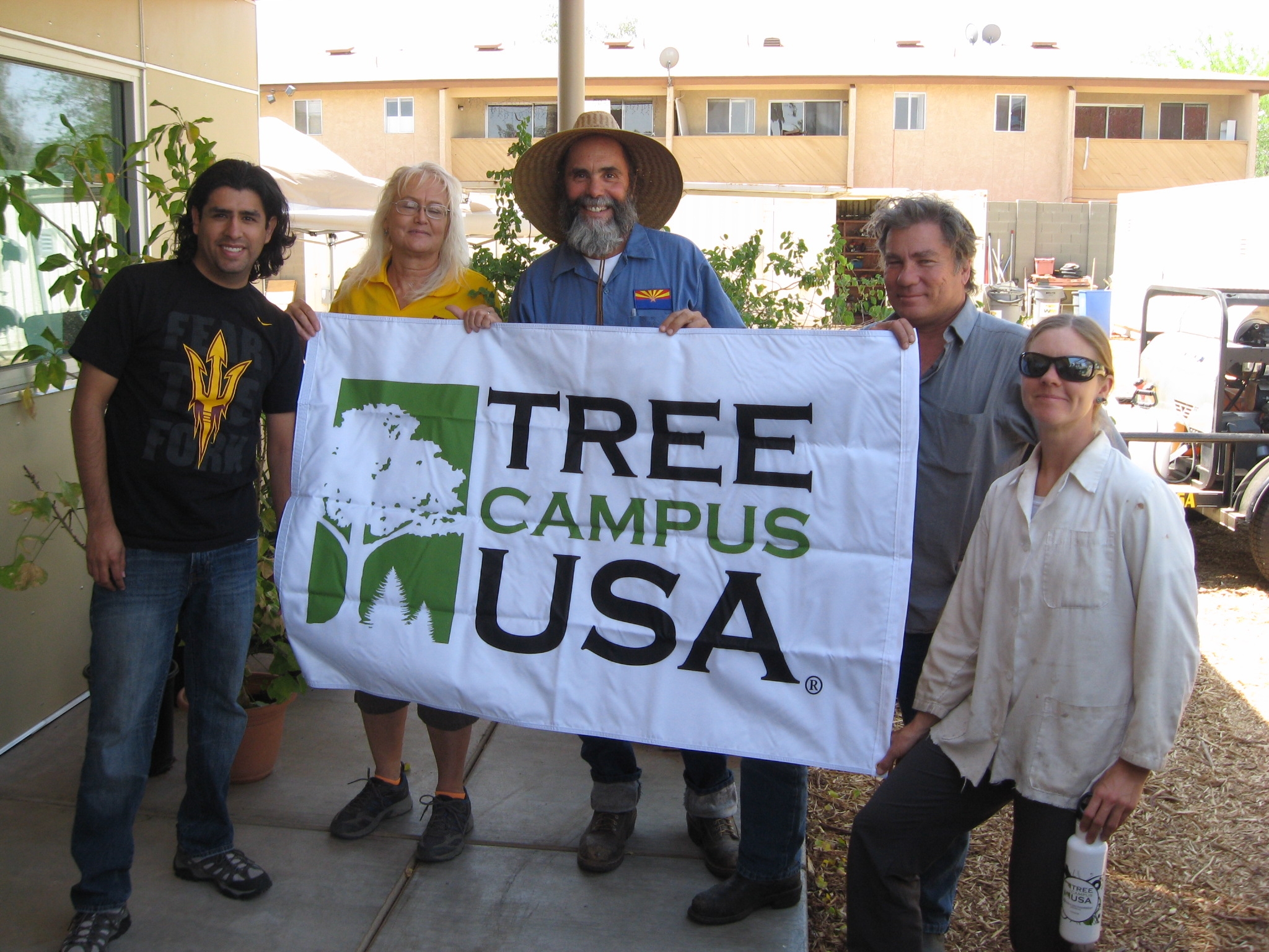 A group holds a Tree Campus USA sign.